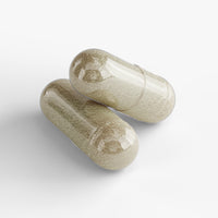 Close-up of a Thrive Hive Women's Essentials capsule, a blend of vitamins and herbs for women's health.