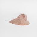 A scoop of chocolate-flavored collagen powder being added to a drink.